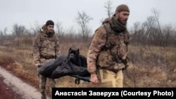 Украинские военные несут Васю после полученной травмы