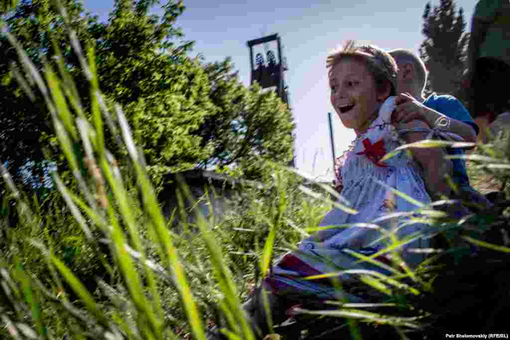 "Там хлопки такие сильные - это наши стреляли. А потом мы пошли в бомбик", - дети показывают свежие воронки в земле. Днем они гуляют на улице, вечером возвращаются домой - в бомбоубежище. Многие из них живут под землей уже почти год