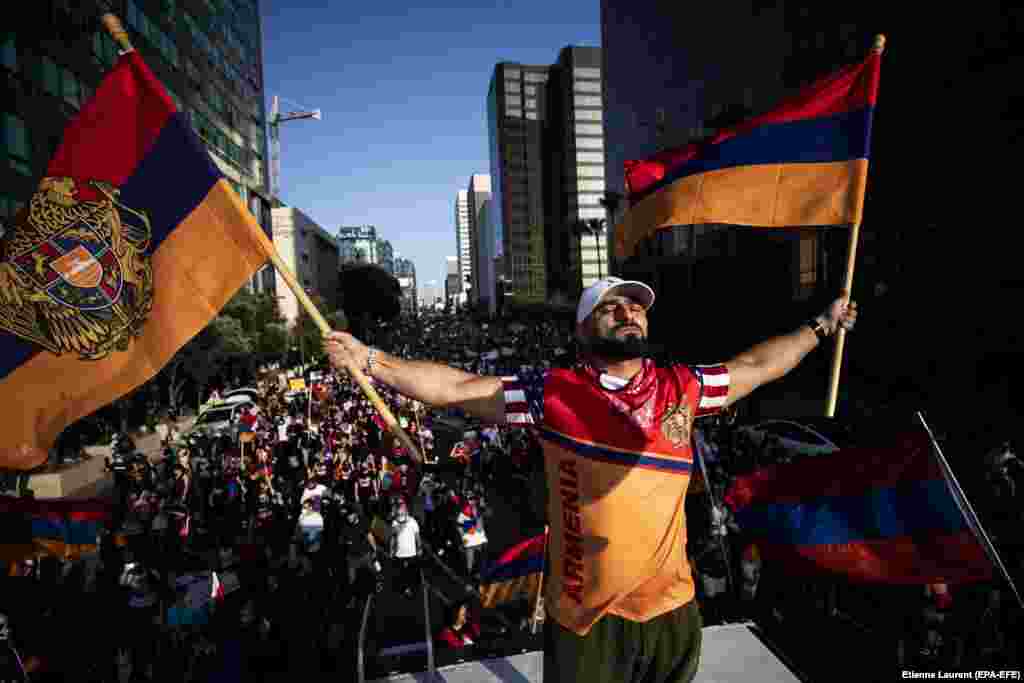 Arkady Grigorian stands on the roof of an RV waving Armenian flags as thousands of American-Armenian protesters march in front of Turkey's consulate in Los Angeles, California on October 11.&nbsp; Southern California is estimated to contain the world's largest Armenian diaspora.&nbsp;