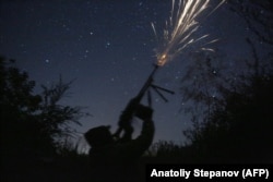 A Ukrainian serviceman fires at a drone from the frontline with Russia-backed separatists near the town of Novgorodsk in Ukraine's Donetsk region on September 17, 2021.