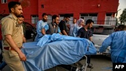 Парамедики и сотрудники полиции несут туриста, раненного во время нападения 22 апреля 2025 года