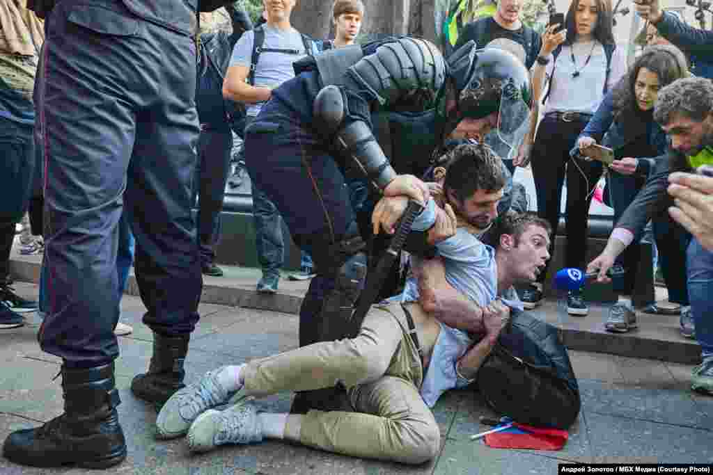 Корреспондент Настоящего Времени Тимур Олевский (справа) интервьюирует задерживаемых на Чистых прудах. Фото: Андрей Золотов / "МБХ-Медиа"