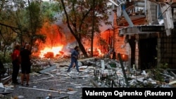 Киевляне возле разрушенного во время российской атаки дома. 31 июля 2025 года