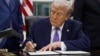 U.S. President Donald Trump signs an executive order in the Oval Office of the White House
