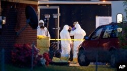 Работники ФБР в костюмах химической защиты осматривают дом после серии рициновых отравлений