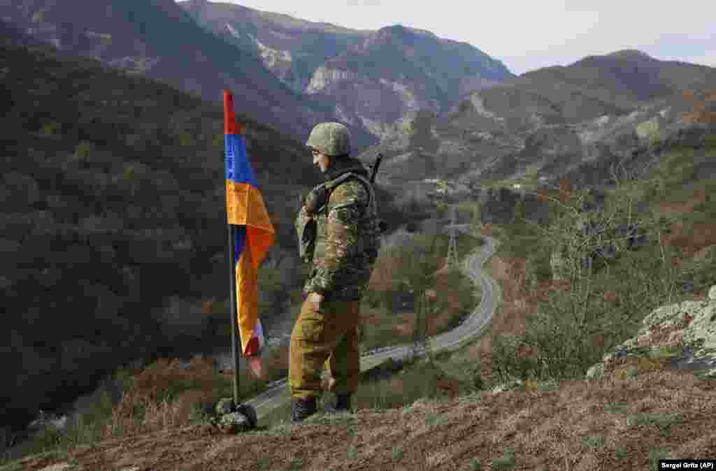 Atop a hill near the village of Charektar, not far from Azerbaijan's newly regained Kalbacar district, an ethnic Armenian soldier keeps watch next to the flag of breakaway Nagorno-Karabakh. Ethnic Armenian separatists still run Karabakah's de facto government despite the loss of large amounts of area territory to Azerbaijani forces.&nbsp;