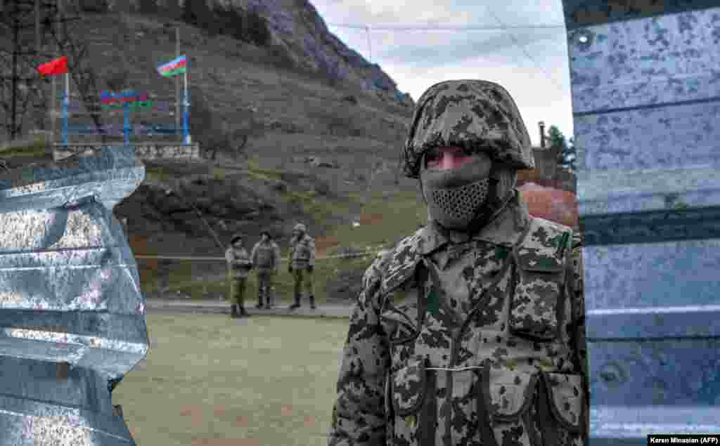 Azerbaijani soldiers stand at a checkpoint on a road outside the Nagorno-Karabakh town of Shusha (Shushi in Armenian) on November 26, 2020. After Azerbaijan regained control of the town in early November, relatively little has been reported about conditions there. Shusha, located about 10 kilometers from Karabakh's seat, Khankendi (Stepanakert), was seen as a strategic win for Azerbaijan because of its hilltop position.&nbsp;