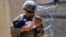 AFGHANISTAN -- A U.S. Marine assigned to 24th Marine Expeditionary Unit (MEU) comforts an infant while they wait for the mother during an evacuation at Hamid Karzai International Airport, in Kabul, August 21, 2021