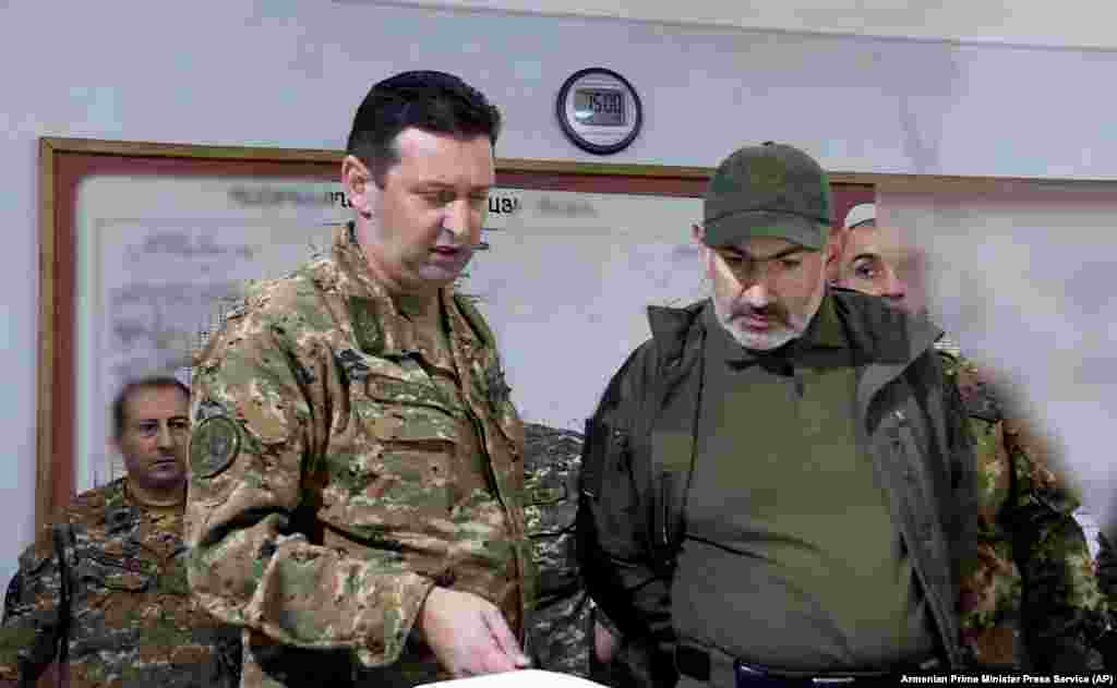 In this photo from the Armenian government, Armenian Prime Minister Nikol Pashinian, right, attends an October 6, 2020 meeting with army commanders in the breakaway Nagorno-Karabakh region. A teenager during the 1988-1994 Karabakh conflict with Azerbaijan, Pashinian, unlike his predecessor, former Prime Minister and President Serzh Sarkisian, a Karabakhi native and commander of the region's fighters during the initial conflict with Azerbaijan, has no firsthand military experience in the region.&nbsp;