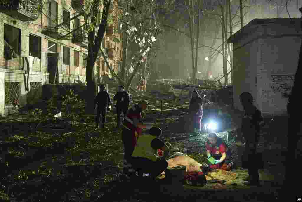 Украинские врачи оказывают помощь мужчине, пострадавшему в результате атаки российской баллистической ракеты на Киев