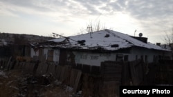 Надпись "Здесь еще живут" на стене дома в поселке Жезказган в Казахстане