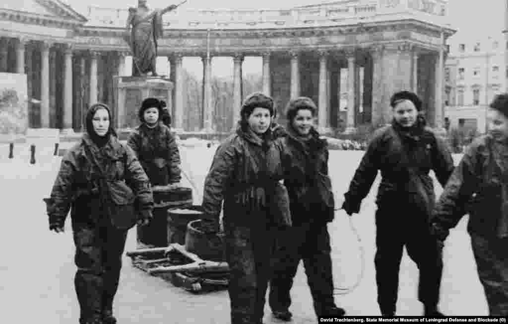 Давид Трахтенберг. Девушки-бойцы МПВО у Казанского собора. 1942 год. "Безжизненные дома с зияющими глазницами окон; снимки людей, расчищающих улицы от завалов, марширующих рабочих отрядов, обозов с хлебом и машин на Дороге жизни. Но эти снимки не передавали того ужаса, который владел авторами книги, когда они слушали воспоминания блокадников", &ndash; так о военных снимках тех лет писали авторы "Блокадной книги" Даниил Гранин и Алесь Адамович